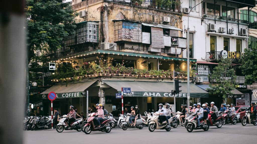 A cafe on a street corner in Hanoi's Old Quarter amid morning motorbike traffic