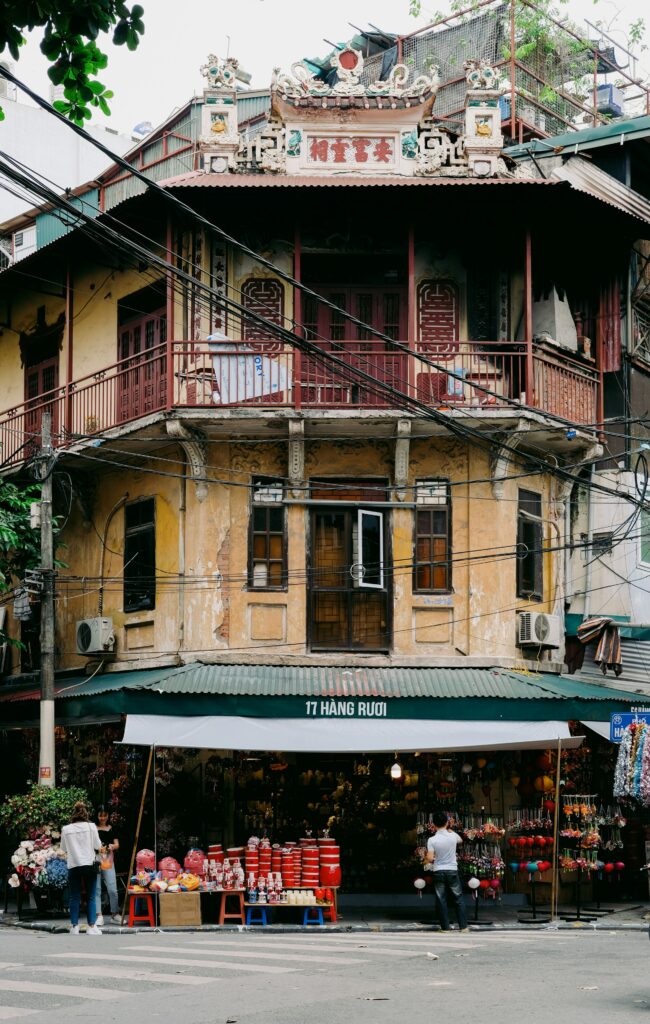 A vendor carrying baskets through the streets of old Hanoi