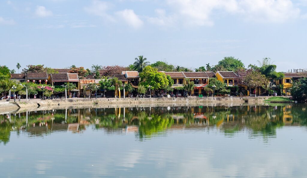 Historic yellow riverside houses reflected on the Thu Bon River in Hoi An