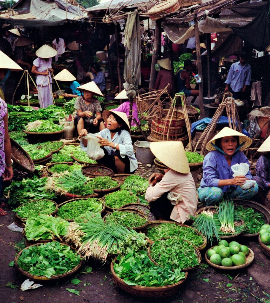 Shoppers choosing fresh herbs and produce at a Vietnamese market