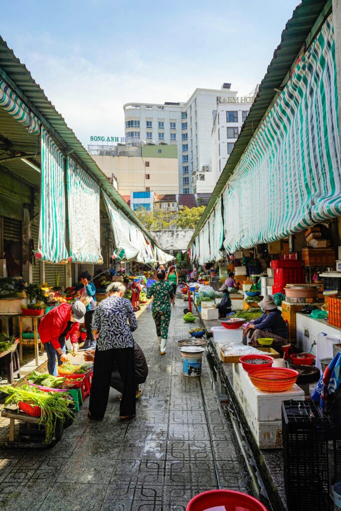 A vendor arranging fresh herbs at Ben Thanh Market, Saigon