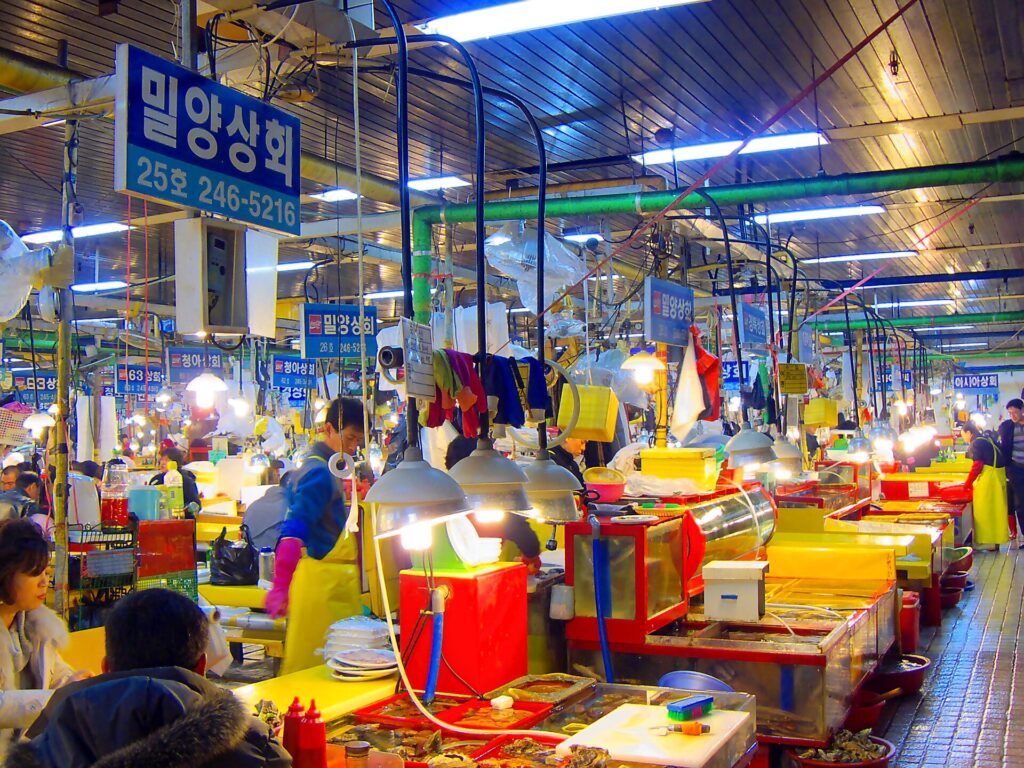 Vibrant red and yellow seafood stalls glowing inside Jagalchi Market in Busan